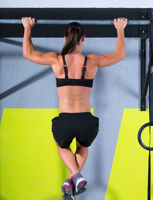 Fitness woman doing pull-ups exercise for back muscles, working