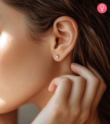 A woman changing her ear piercing jewelry