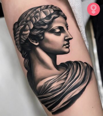 A woman with a Greek statue tattoo on the arm