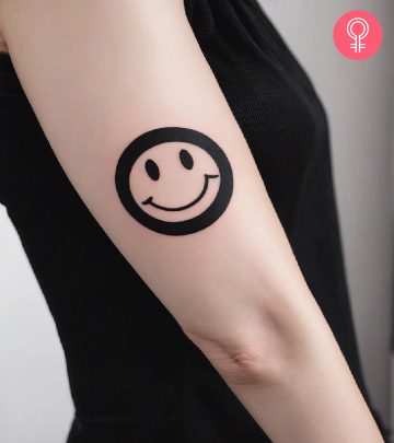 A woman with a smiley face tattoo on her arm
