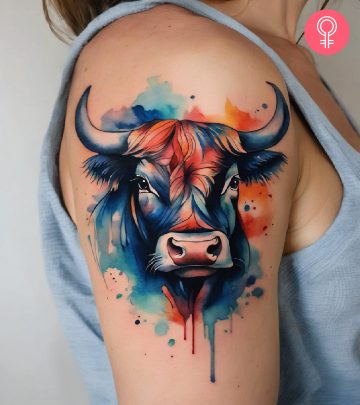 A vibrant bull head tattoo on a woman’s upper arm
