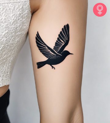 A woman with a freedom tattoo on the upper arm