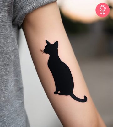 Cat silhouette tattoo on the arm of a woman