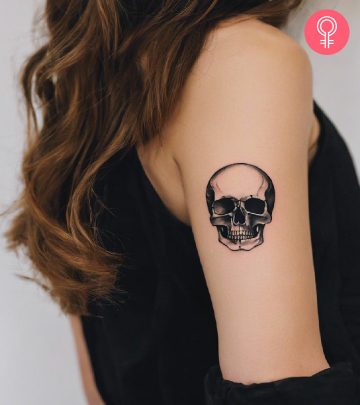 Woman with skull tattoo on her upper arm