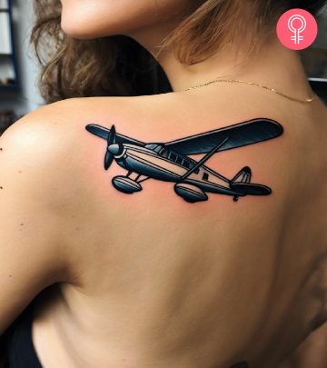 Woman with a seaplane tattoo on the back of the shoulder