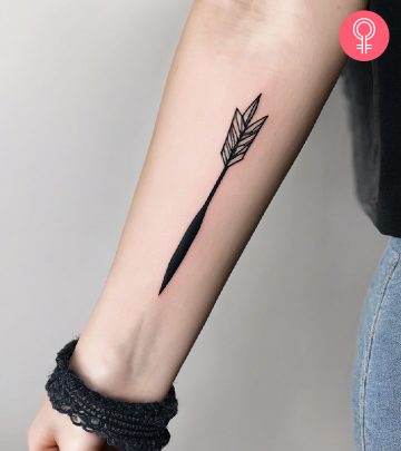 Woman with a dart tattoo on the forearm