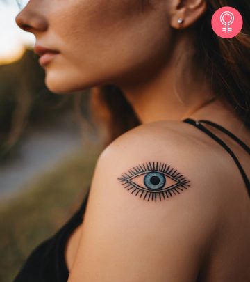 An evil eye tattoo on the upper arm of a woman
