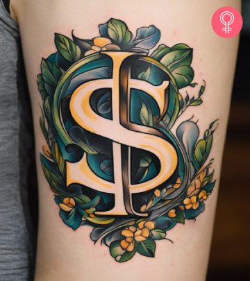 A dollar sign tattoo on a woman’s upper arm