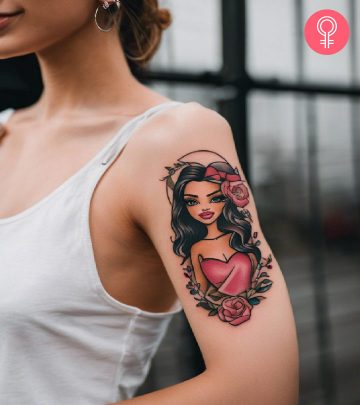 A Bratz doll tattoo with flowers on the upper arm