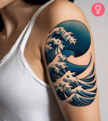 A Japanese wave tattoo on the upper arm of a woman