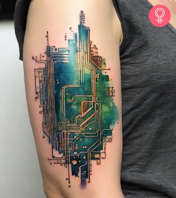 A circuit board tattoo on the upper arm of a woman
