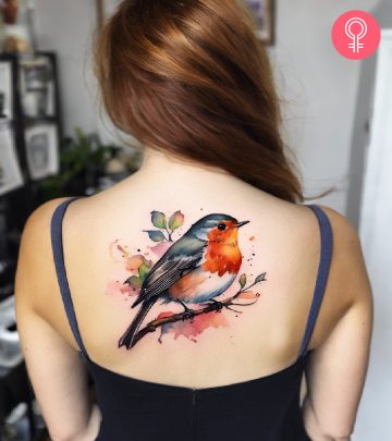 A colorful watercolor tattoo of a robin on the back
