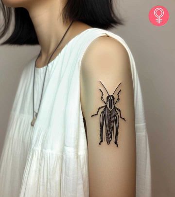 A grasshopper tattoo on the upper arm of a woman