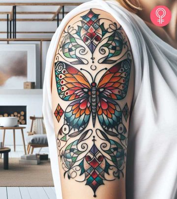 A mosaic tattoo of a bird on the back of the shoulder