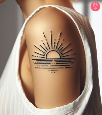 A tattoo of a serene sunrise on a woman’s arm