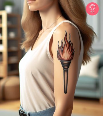 A torch tattoo on the upper arm of a woman