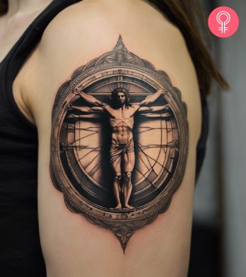 A vitruvian man tattoo on the upper arm of a woman