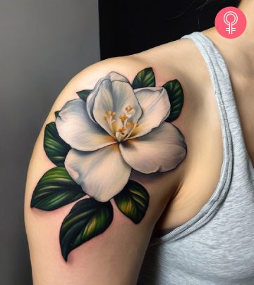 A woman wearing a gardenia tattoo on her shoulder