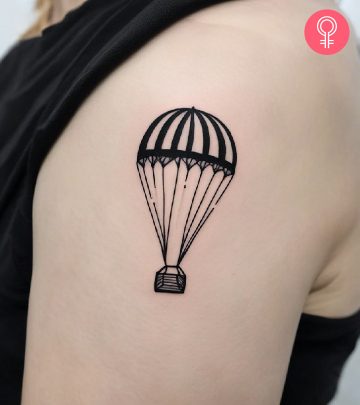 A woman with a black parachute tattoo on her upper arm
