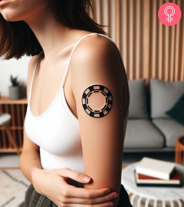 A woman with a minimalist poker chip tattoo on her upper arm