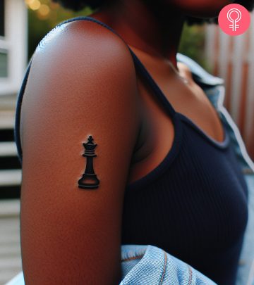 A woman with a queen chess piece tattoo on her upper arm