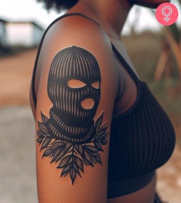 A woman with a ski mask tattoo on the upper arm