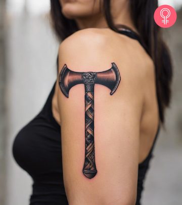A woman with a tomahawk tattoo on her upper arm