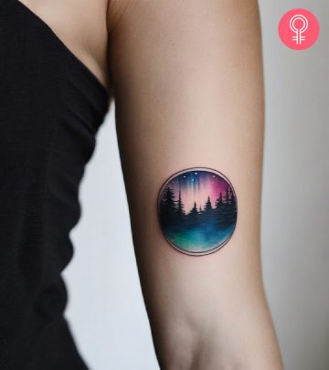 A woman with vibrant aurora borealis tattoo on her upper arm