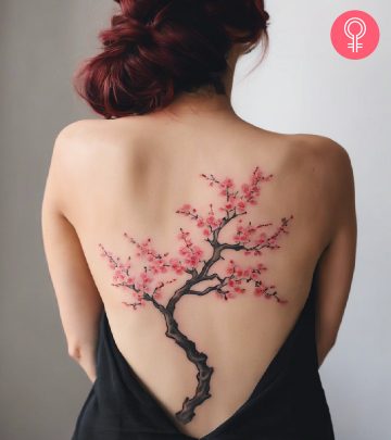 A woman with a Japanese back tattoo featuring a cherry blossom tree