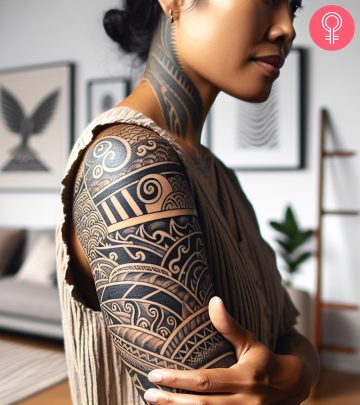 An intricate tattoo on the upper arm of a woman