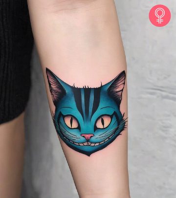 Cheshire cat tattoo on the upper arm