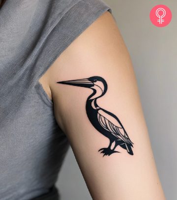 A black pelican tattoo on the upper arm