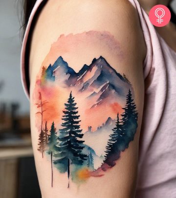 Mountains and pine trees tattoo on the arm