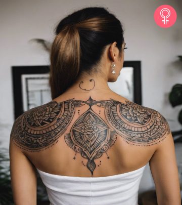 Symmetrical floral tattoo on the upper back of a woman