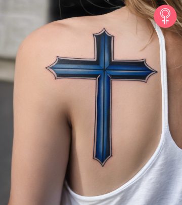 Thin blue line cross tattoo on a woman’s upper arm