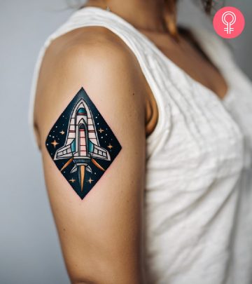 A spaceship tattoo on the upper arm of a woman