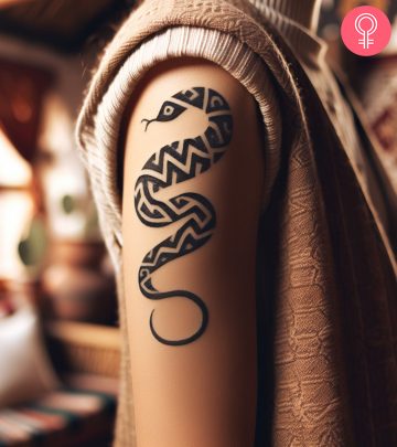 Tribal snake tattoo on the upper arm of a woman