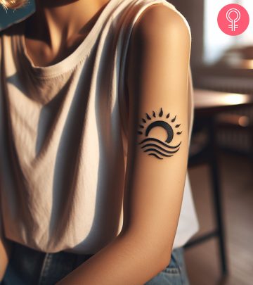 Wave and sun tattoo on the arm of a woman
