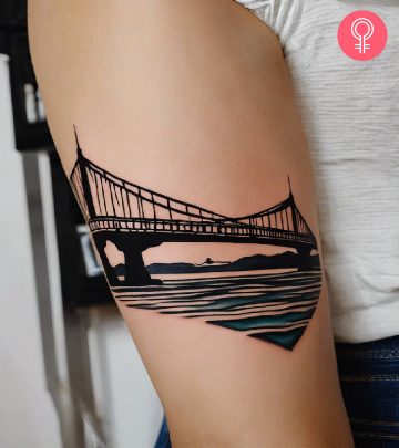 Woman with a bridge tattoo on the upper arm