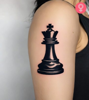 Woman with a king chess piece tattoo