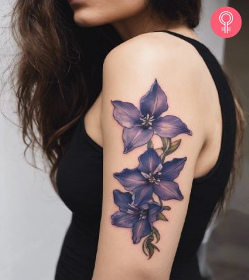 Woman with a tattoo of larkspur flowers on her shoulder