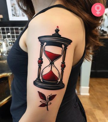 Woman with fate tattoo featuring hourglass on her arm