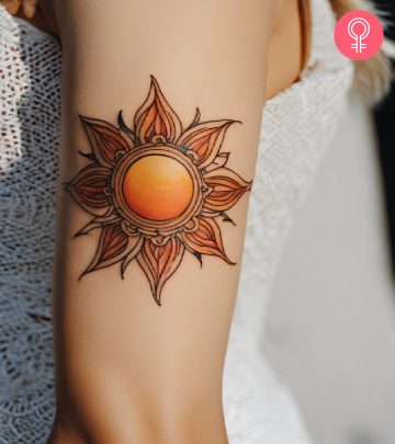 Woman with sun tattoo on her arm