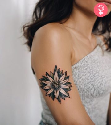 A woman with a colored Edelweiss flower tattoo on her upper arm