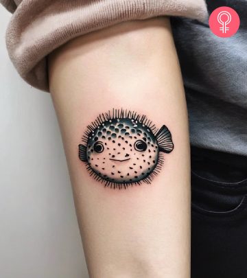 A cute puffer fish tattoo on a woman’s forearm