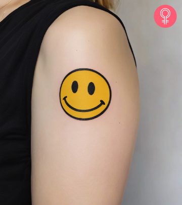 A smiling emoji on a woman’s arm