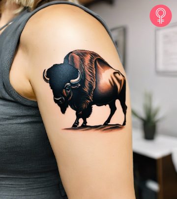 A woman with a traditional buffalo tattoo on her upper arm