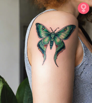 A woman with a vibrant luna moth tattoo on her upper arm