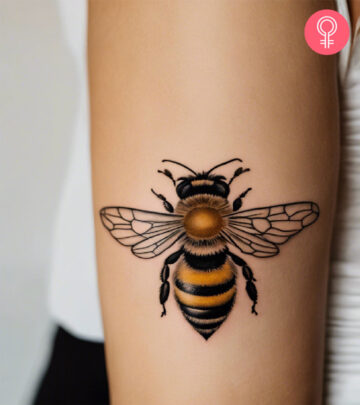 A woman with a honey bee tattoo on her upper arm